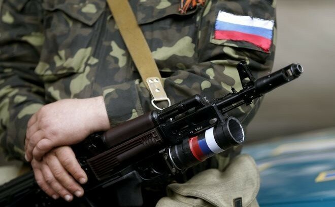 Вооруженный пророссийский активист стоит у захваченного здания обладминистрации в Луганске